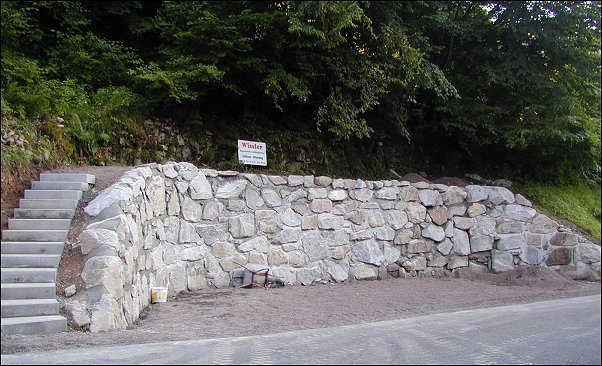 Natursteinmauer mit Treppenaufgang in Rohmatt